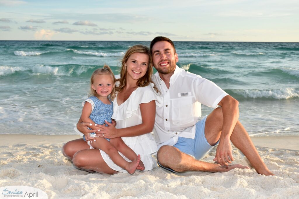 A family sitting on the beach.