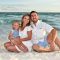 A family sitting on the beach.