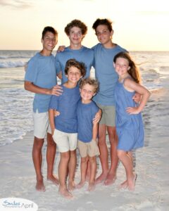 A group of kids standing on the beach