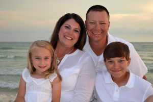 family smiling in a beach photo