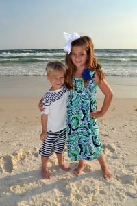 boy and girl in a beach photo at sunset smiling at our Panama City Beach photographer