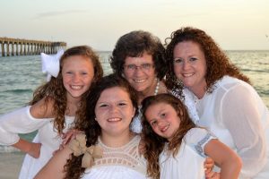 family beach photo with pier in background