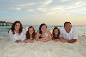 family posing on the sand