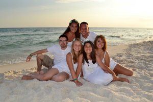 family sitting on the sand