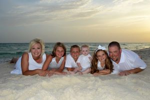 family laying on the sand