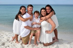 Family posing on Panama City Beach in the soft morning sun.