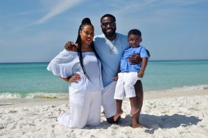 family smiling for their beach photo