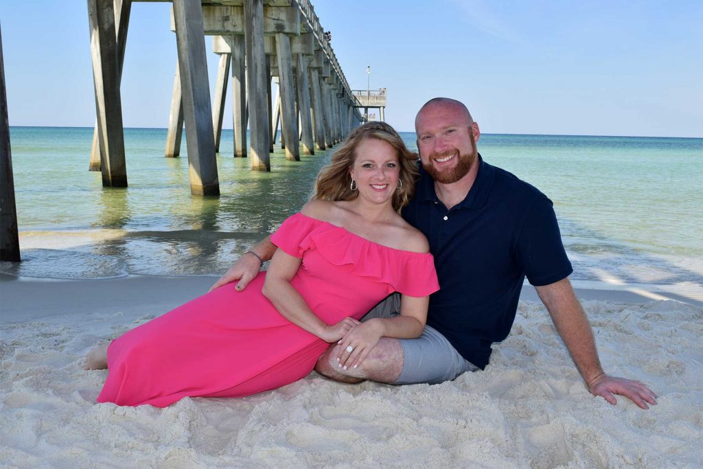 couple on the beach under the pier in Panama City Beach, FL.