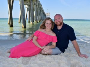 couple on the beach under the pier in Panama City Beach, FL.