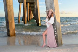 girl posing for her senior portraits at the beach