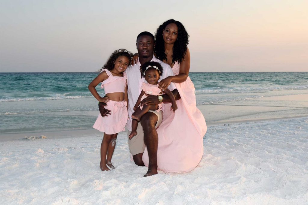 Family on the beach smiling at our PCB photographer