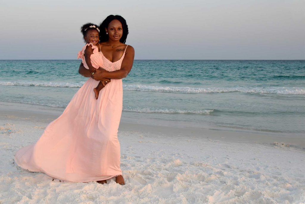 Mom holding baby on Panama City Beach at sunset