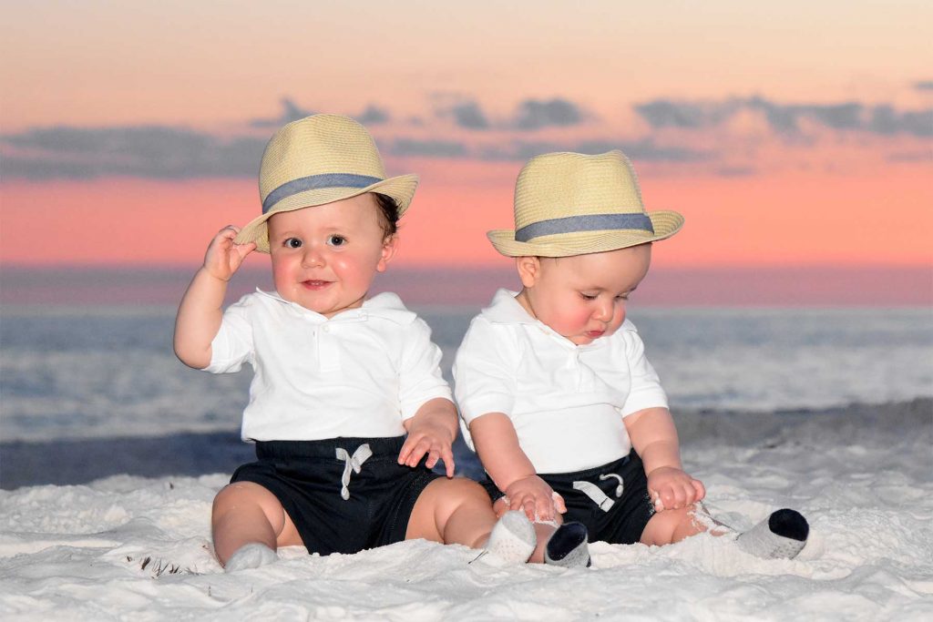 Adorable baby boys getting photographed on the beach at sunset