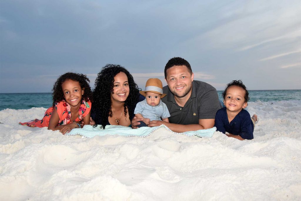 Family in a cute beach pose at sunset