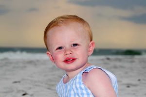 cute baby in blue smiling in sunset baby photo