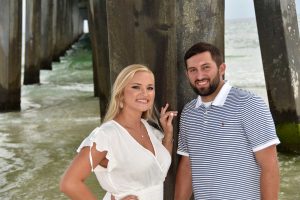 Couple under the pier during PCB sunset.