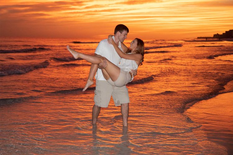 Man carrying woman through the water