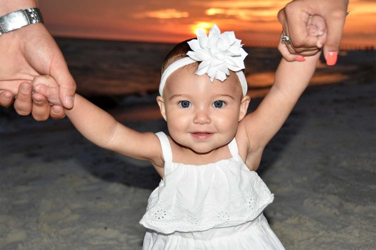 Baby with arms up. We take sunset family photos in Panama City Beach.