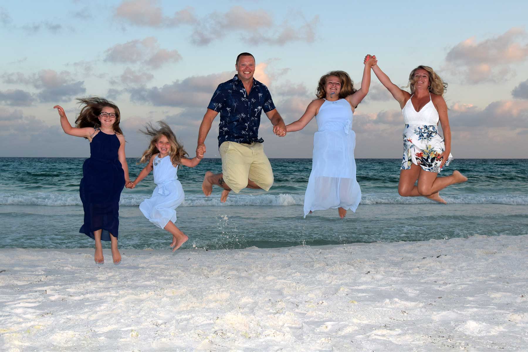 family jumping in the air for photographer