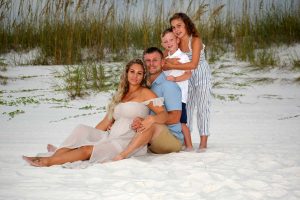 family posing with sea oats behind them