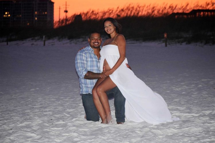 couple posing in front of gorgeous red sunset