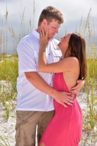 Our photographer captures this lovely sea oat photo. The couple is in the foreground with the sea oats, beach, and water behind them.