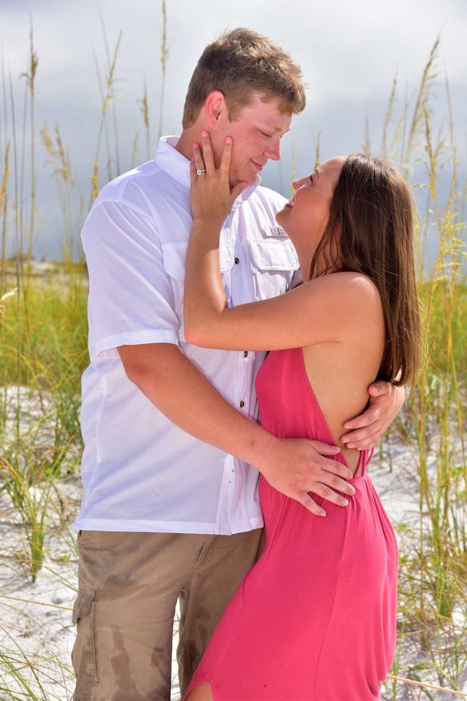 Our photographer captures this lovely sea oat photo. The couple is in the foreground with the sea oats, beach, and water behind them.