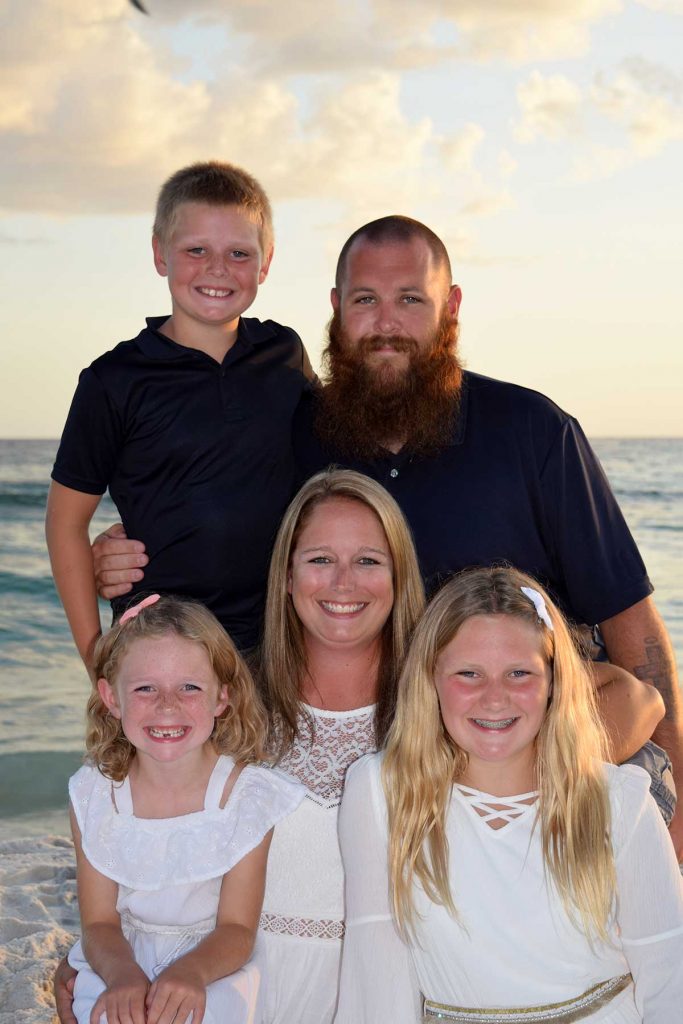 Family smiling in stunning sunset beach photo in Panama City Beach