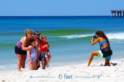 One of our photographers, April, taking family beach photos. Visit PCB this summer for a safe, fun vacation.
