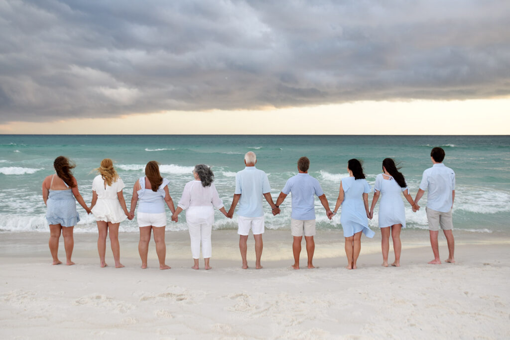 Family photographer in Panama City beach capturing looking at Gulf.