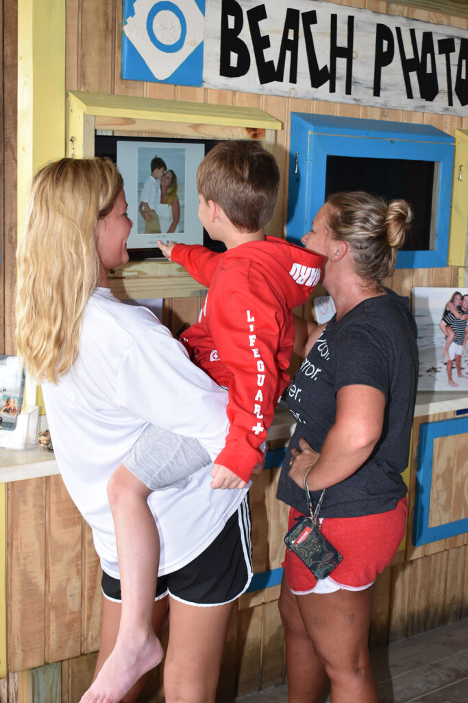 Family looking at their beach photos at our photo kiosk in Panama City Beach, FL.