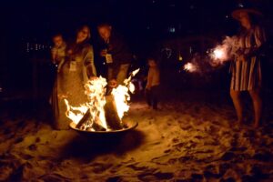 Night photo with family behind the beach bonfire