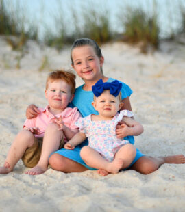Siblings near dunes in Panama City Beach smile for our photographer.