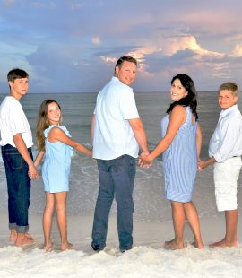 Family looking back and smiling during a sunset session with a Panama City beach photographer at Panama City Beach.