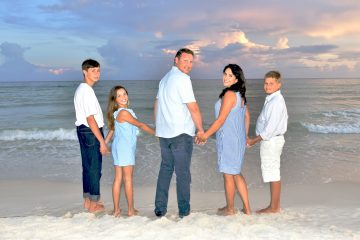 Family looking back and smiling during a sunset session with a Panama City beach photographer at Panama City Beach.